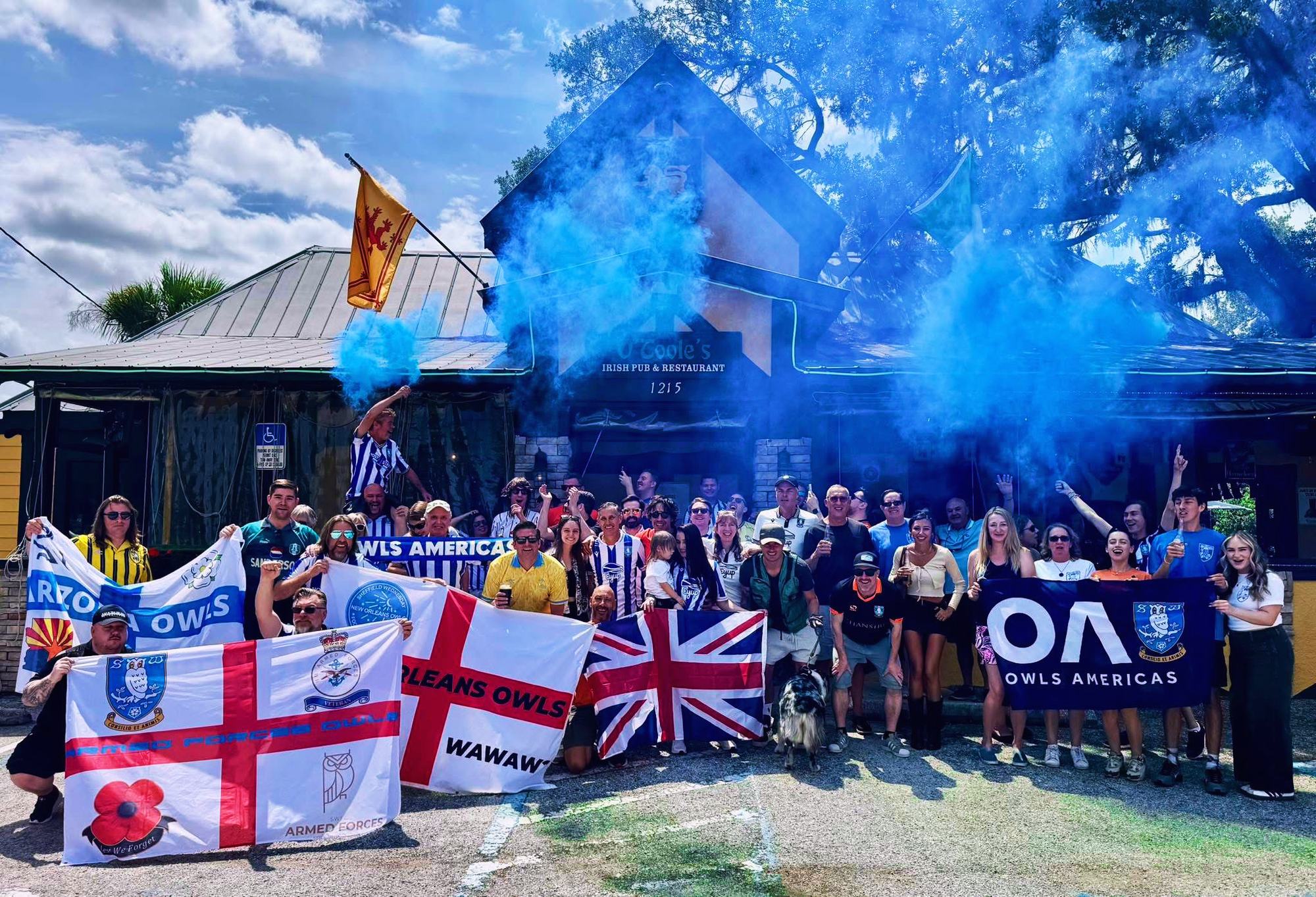 A big crowd of Owls fans in Tampa with flags and blue smoke